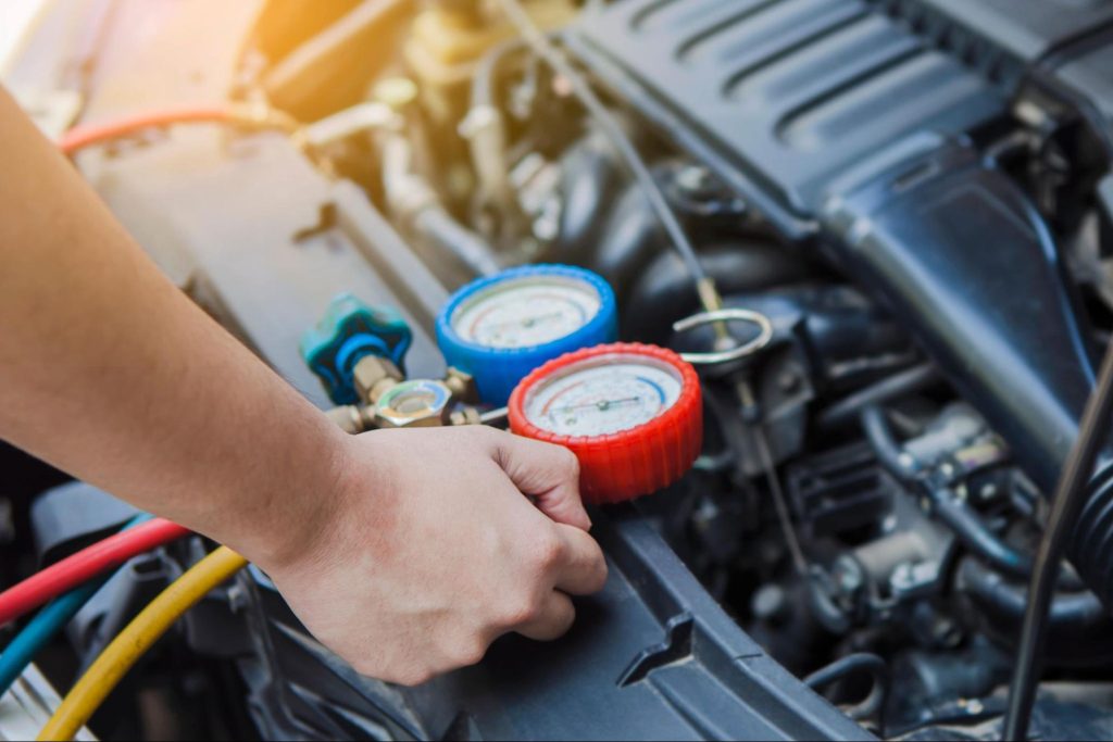 Uma pessoa com equipamentos perto de um motor de caminhão